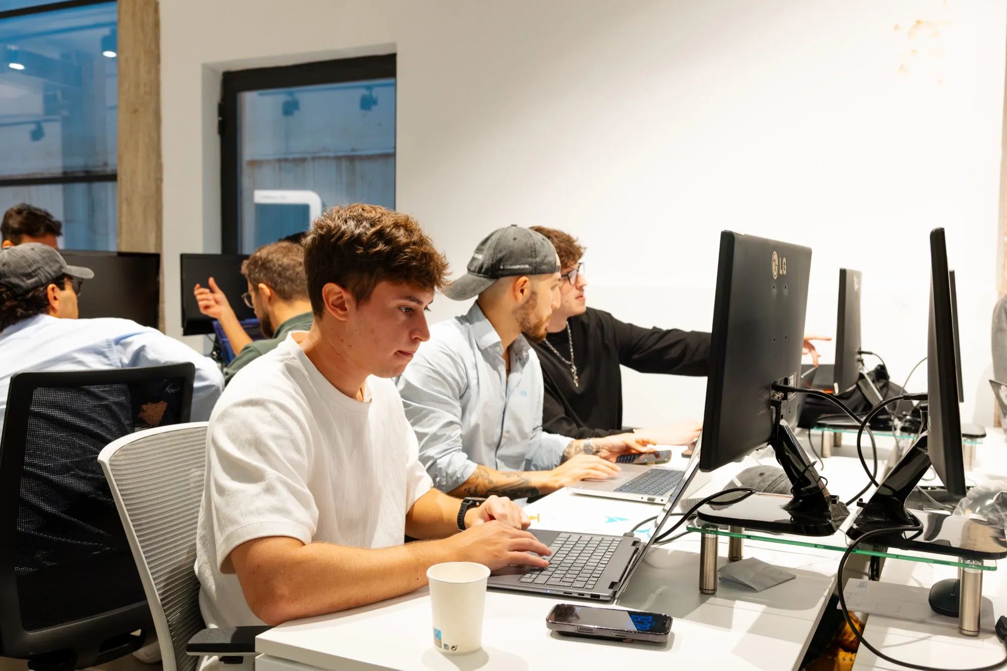 The three team members working at their laptops